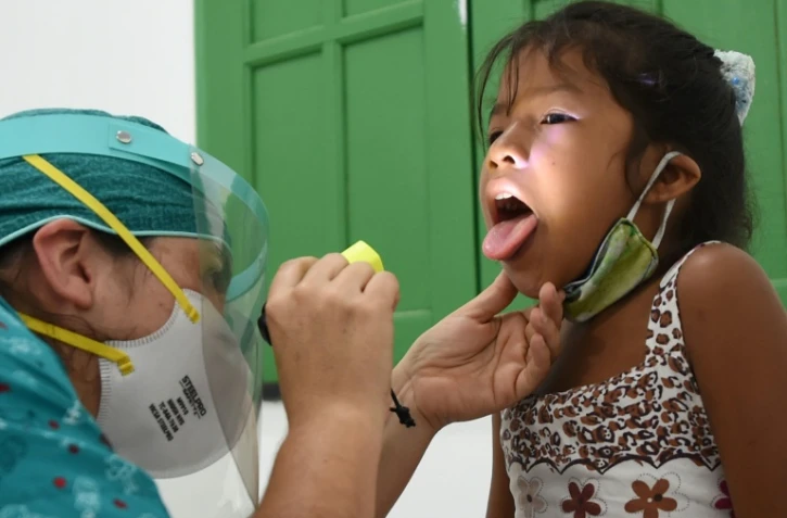 Une enfant reçoit des soins médicaux dans un dispensaire du village d'Umariacu, en Amazonie brésilienne, le 19 juin 2020