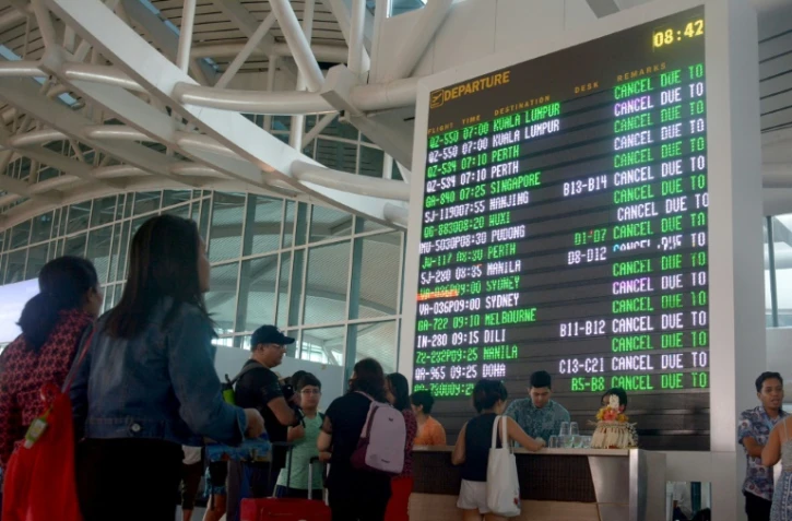Des touristes bloqués à l'aéroport Ngurah Rai à Denpasar, sur l'île de Bali, le 29 juin 2018, après l'éruption d'un volcan