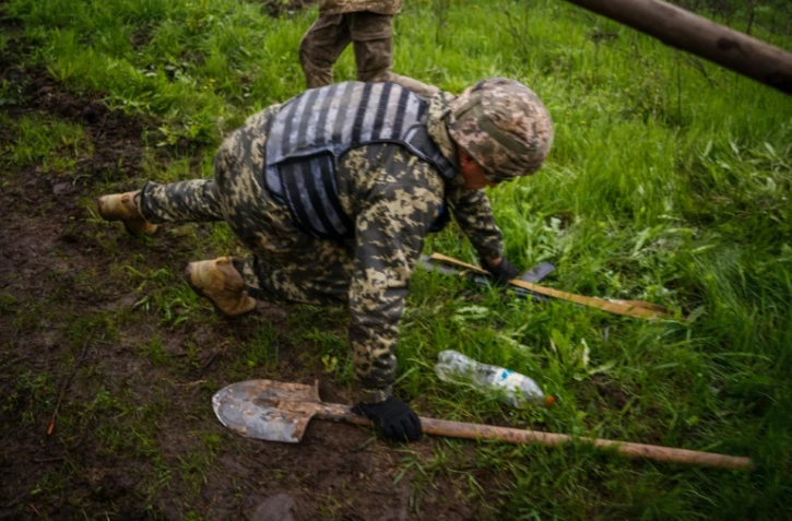 Des soldats ukrainiens se mettent aux abris lors d'un bombardement près de Bakhmout, dans l'Est de l'Ukraine, le 30 avril 2023 