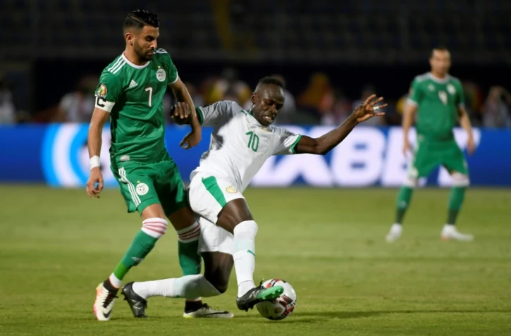 L'attaquant algérien Riyad Mahrez (g) à la lutte avec celui du Sénégal lors de la CAN-2019 , le 27 juin 2019 au Caire