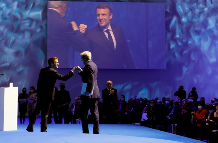 Le président Emmanuel Macron (g) salue l''envoyé américain pour le Climat John Kerry (d), à l'ouverture du sommet pour l'Océan, le 11 février 2022 à Brest