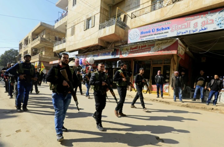 De jeunes civils kurdes syriens défilent dans la ville d'Afrine le 28 janvier 2018 après s'être enrôlés pour résister à l'offensive turque contre cette région du nord-ouest de la Syrie