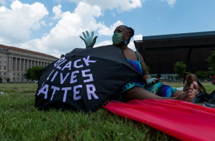une femme arbore un parapluie "Black Lives Matter" le 4 juillet 2020 à Washington
