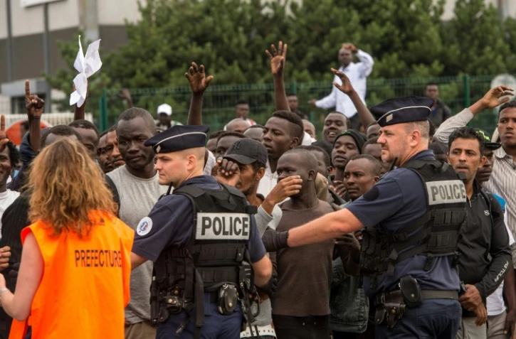 Une chargée de mission de la Préfecture du Nord-Pas-de-Calais sélectionne les migrants qui pourront monter à bord d'un bus à destination d'un Centre d'accueil et d'orientation, le 13 septembre 2016 à Calais