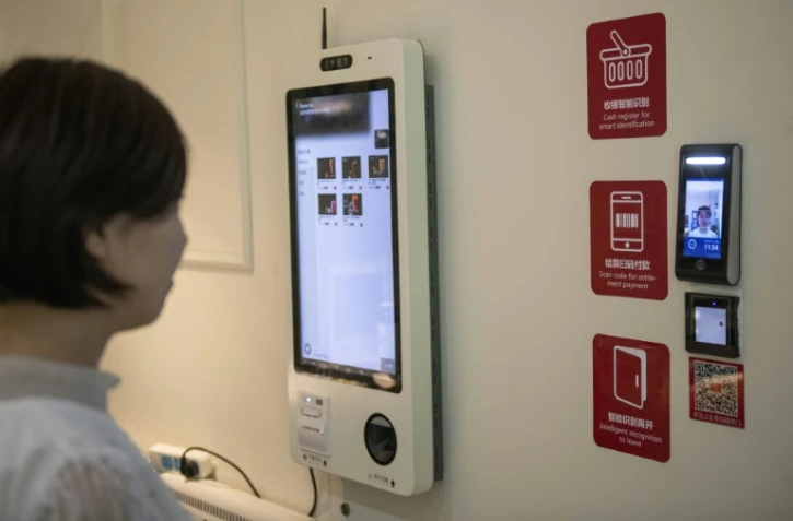 Une femme utilise un terminal de reconnaissance faciale le 21 août 2019 dans un supermarché à Tianjin (Chine)