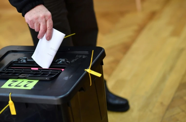 Un électeur irlandais dépose son bulletin de vote samedi 8 février dans un bureau de vote de Dublin à l'occasion des élections législatives.
