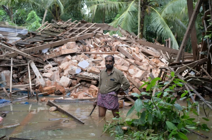 Ajith Prasad devant les restes de sa maison détruite par les inondations dans la province du Kerala au sud de l'Inde, le 17 août 2018