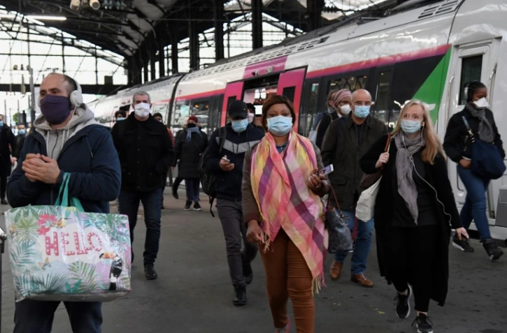 Des usagers portant des masques de protection arrivent à la gare Saint-Lazare, le 11 mai 2020 à Paris, au premier jour du déconfinement en France
