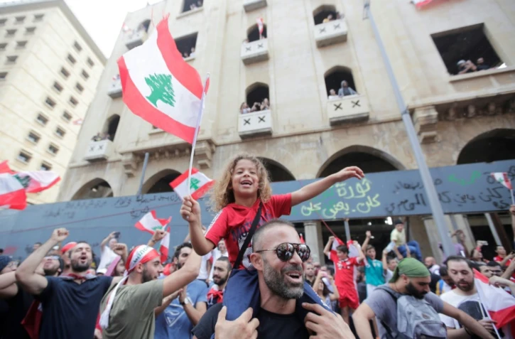 Munis de drapeaux, des manifestants se rassemblent dans le centre de Beyrouth pour protester contre la classe politique libanaise accusée de corruption, le 20 octobre 2019