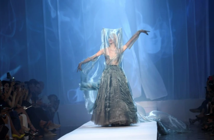 Des volutes virtuelles de cigarette accompagnent les créations de Jean-Paul Gaultier présentées lors d'un défilé automne/hiver 2018/2019 à Paris le 4 juillet 2018