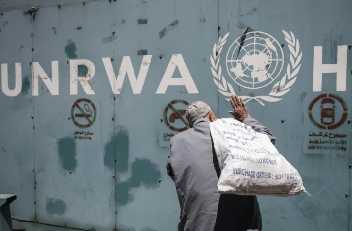 Un Palestinien devant l'emblème de l'Unrwa, l'agence de l'ONU pour les réfugiés palestiniens, devant ses bureaux de la ville de Gaza, le 31 juillet 2018