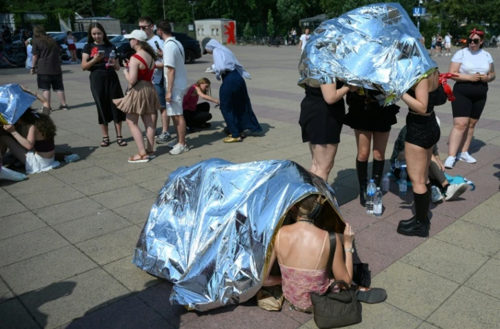 Des spectateurs se protègent de la chaleur avant un concert de Bruo Mars à l'Olympic stadium  de Berlin, le 28 juin 2026