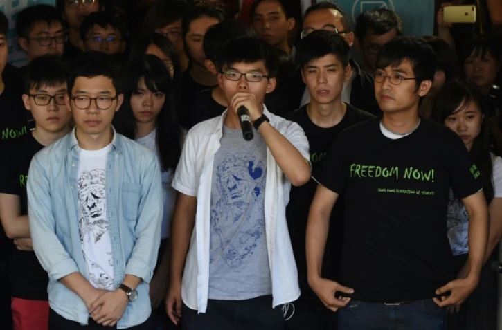 Les trois leaders du vaste prodémocratie Joshua Wong (c), Nathan Law (g) et Alex Chow (d) s'adressent aux médias avant le verdict au tribunal de Hong Kong, le 17 août 2017  