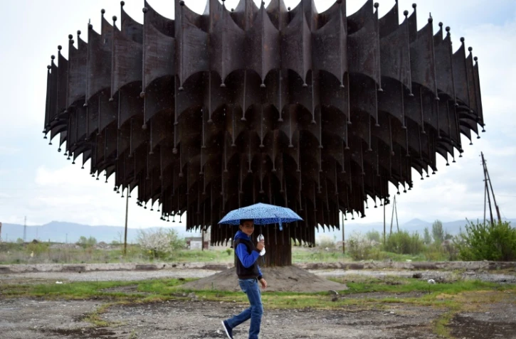 Un jeune Arménien passe devant une fontaine abandonnée dans la ville de Gumri, au nord-ouest d'Erevan, le 5 mai 2018