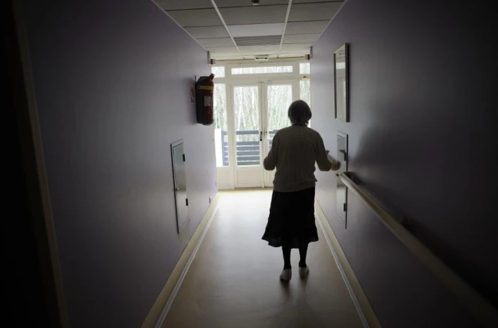 Une femme souffrant de la maladie d'Alzheimer marche dans le couloir d'une maison de retraite à Angervilliers, au sud-ouest de Paris, le 18 mars 2011