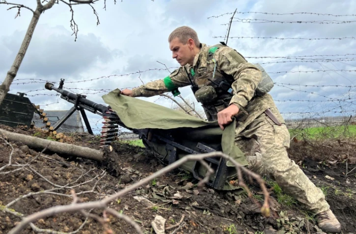 Un officier ukrainien près de sa mitrailleuse lourde sur la ligne du front près de Kharkiv, dans le nord-est de l'Ukraine, le 17 avril 2022