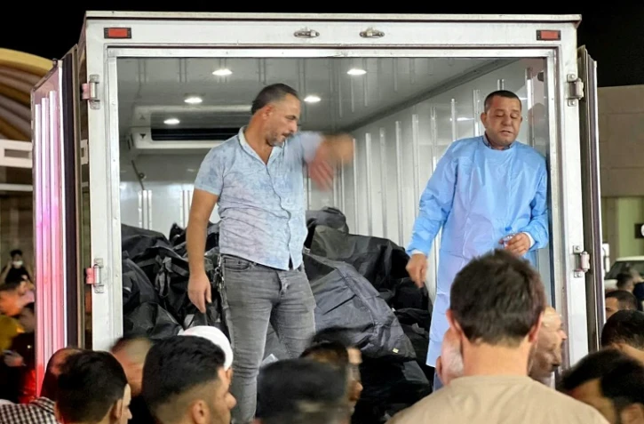 Des corps de victimes de l'incendie pendant un mariage arrivent à bord d'un camion à l'hôpital de Hamdaniyah, en Irak, le 27 septembre 2023