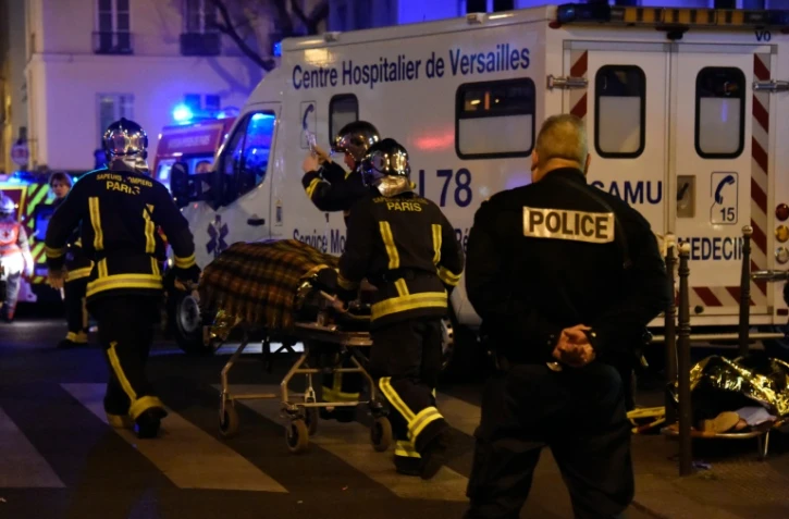 Des pompiers évacuent une personne blessée lors de l'attaque terroriste contre la salle du Bataclan, le 13 novembre 2014 à Paris