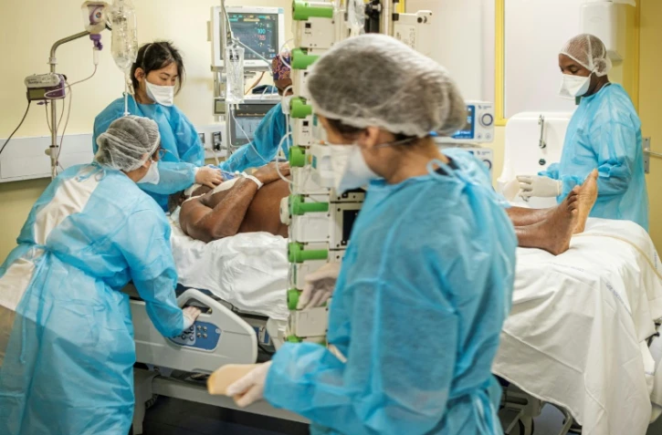 Des membres du personnel hospitalier s'occupent d'un patient malade du Covid-19 en soins intensifs Ă Cayenne le 24 septembre 2021