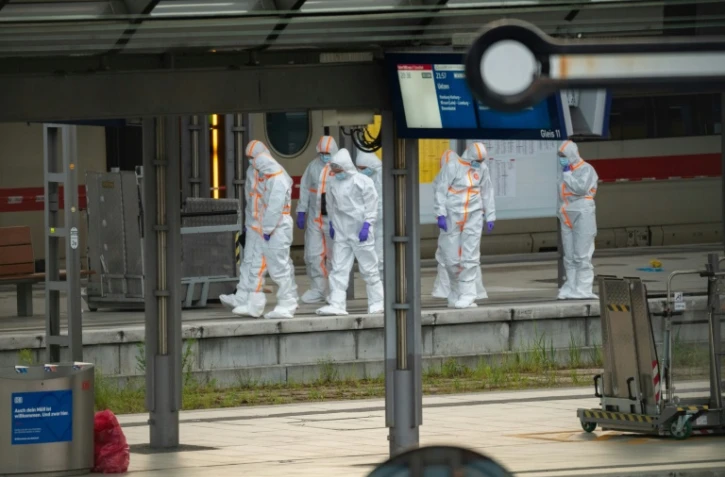 Des membres de la police scientifique sur le quai de la gare centrale de Hambourg, où au moins 12 personnes ont été blessées lors d'une attaque au couteau, le 23 mai 2025 en Allemagne