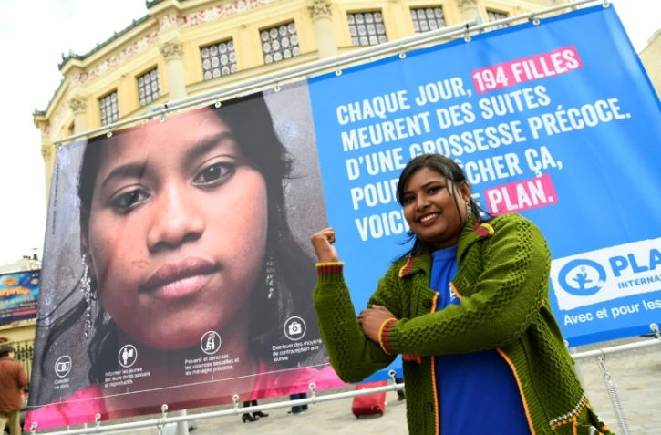 Radha Rani porte-parole de l'ONG Plan international, poses devant une affiche pendant l'inauguration d'une "Place du Calvaire des Filles" devant le Cirque d'Hiver à Paris le 10 octobre 2016