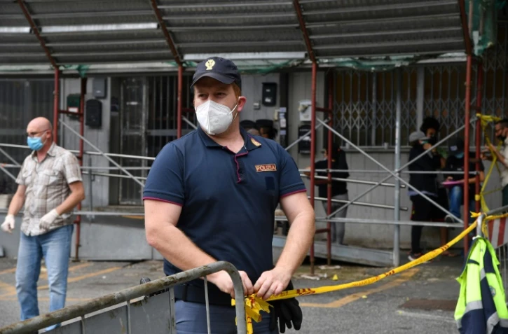 Un policier municipal bloque l'accès à un immeuble où est apparu un nouveau foyer de Covid-19, le 13 juin 2020 à Rome