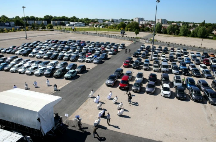 Des automobilistes garés sur un parking pour assister à une messe en plein air célébrée par Mgr François Touvet, l'évêque de Châlons-en-Champagne, le 17 mai 2020