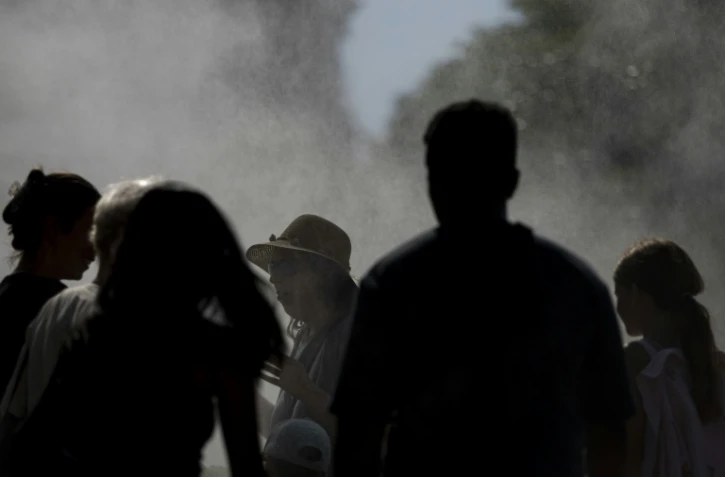 Des personnes sous un systĂšme de rafraichissement pendant la canicule Ă Strasbourg, le 20 juin 2026