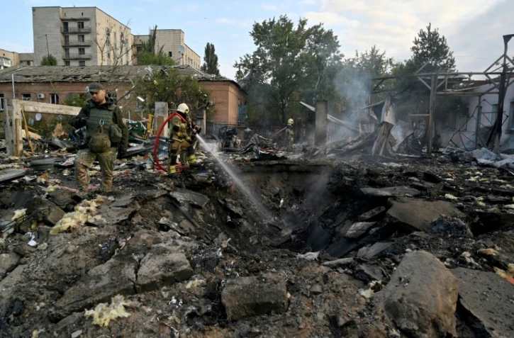 Des pompiers et des policiers sur les lieux d'une frappe russe sur une zone industrielle de Kiev, le 21 septembre 2023 en Ukraine