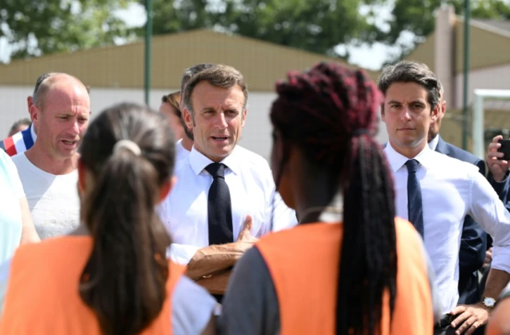 Le président français Emmanuel Macron (c) et le ministre français de l'Education nationale et de la Jeunesse Gabriel Attal (d) s'entretiennent avec des élèves à Orthez, dans les Pyrénées-Atlantiques, le 5 septembre 2023