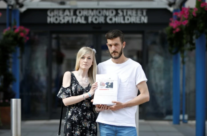 Connie Yates et Chris Gard, parents de Charlie, posent avec la pétition de 350.000 signatures qu'ils vont déposer à l'hôpital pédiatrique Great Ormond Street Hospital for Children à Londres le 9 juillet 2017