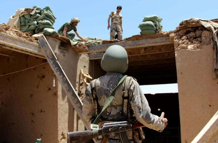 Des policiers des frontières afghans inspectent un bâtiment endommagé après une frappe aérienne américaine dans la province du Helmand (sud), le 10 juin 2017