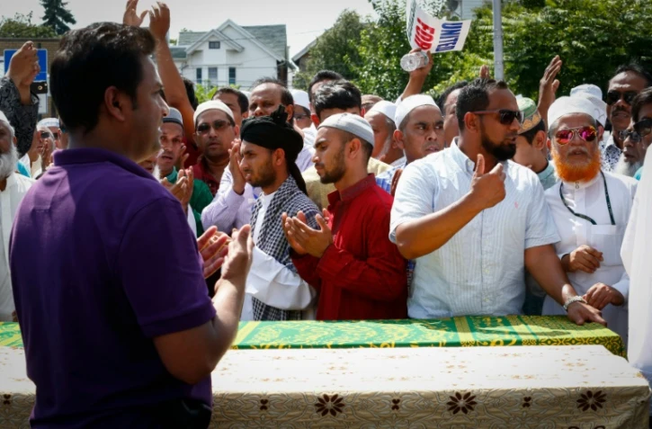 Des hommes prient autour des cercueils contenant les corps d'un imam et de son assistant tués par balles, à New York le 15 août 2016