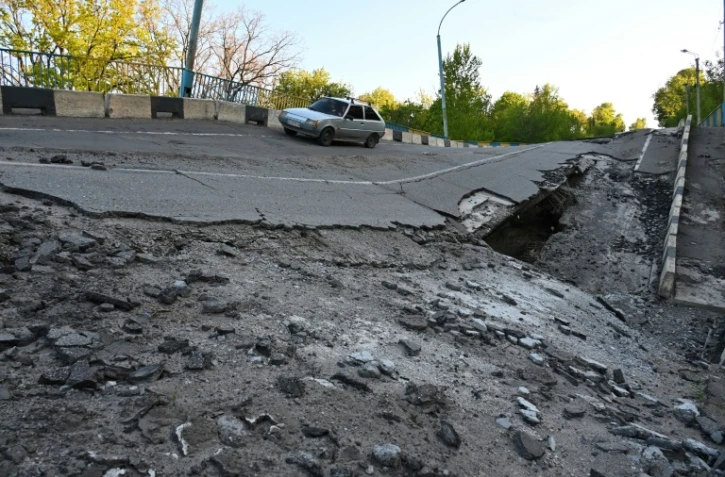 une voiture passe sur un pont endommagé près du village de Pechenegi, dans la région de Kharkiv, le 5 mai 2022
