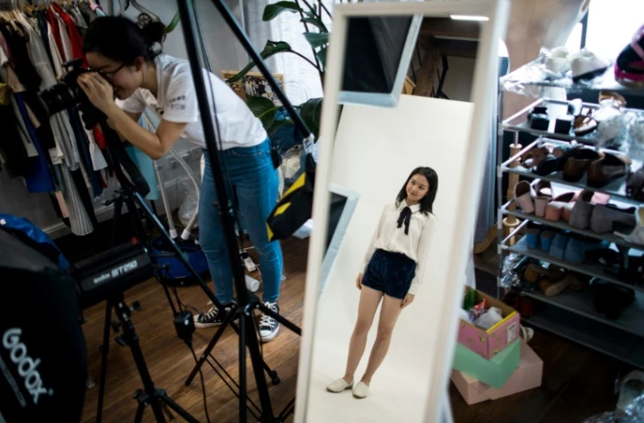 La Chinoise Wang Houhou (g) photographie un modèle pour le lancement de sa boutique de mode en ligne, le 5 mai 2017 à Shanghai