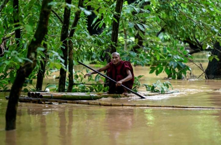 Un moine bouddhiste utilise un radeau de bambou au milieu des inondations à Taungoo, dans la région de Bago, en Birmanie, le 14 septembre 2024