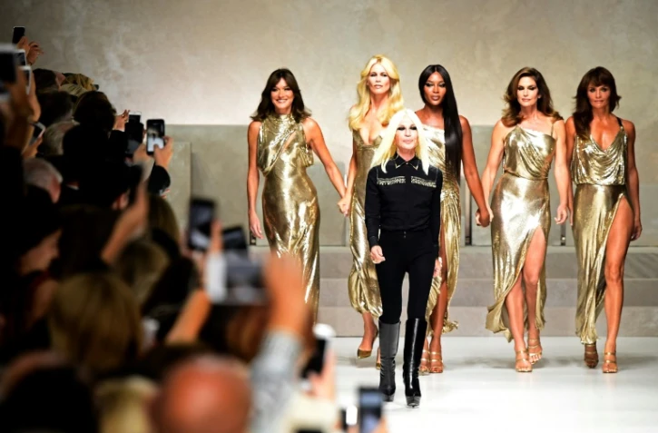 La styliste italienne Donatella Versace (en noir) devant les mannequins stars des années 90 (GàD) Carla Bruni, Claudia Schiffer, Naomi Campbell, Cindy Crawford et Helena Christensen, le 22 septembre 2017 à Milan