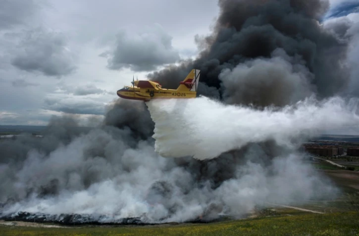 Un hydravion largue de l'eau sur une décharge sauvage de pneus en feu, près de Seseña en Espagne le 13 mai 2016