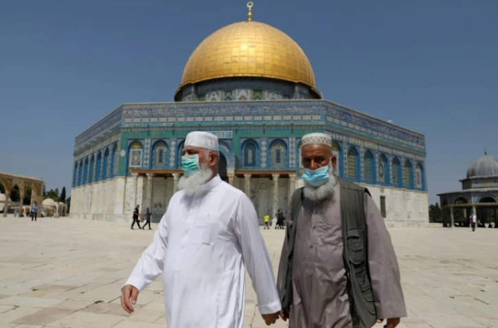 Des Palestiniens portant des masques passent devant la mosquée al-Aqsa à Jerusalem, le 18 septembre 2020