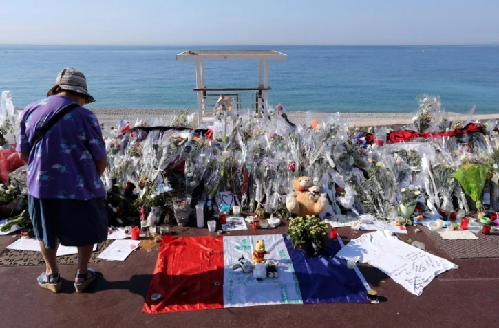 Une femme se recueille, le 19 juillet 2016, devant un mémorial de fortune en hommage aux victimes de l'attentat du 14 juillet 2016 à Nice