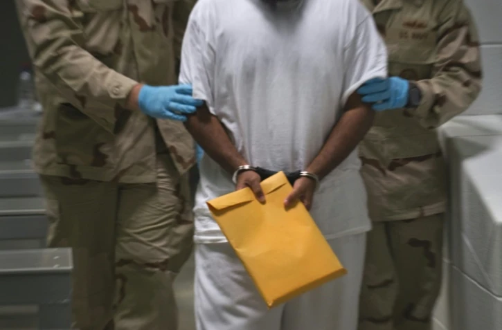 Des soldats américains transfèrent un détenu de Guantanamo, à Cuba, le 30 mars 2010