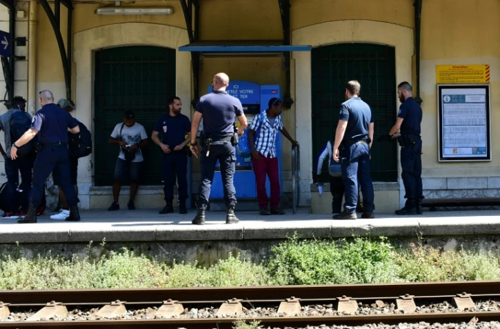 Des policiers contrôlent des migrants qui ont traversé la frontière avec l'Italie, le 14 juin 2018 à la gare de Menton