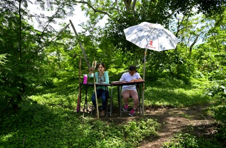 Les s?urs Matilde (g) et Marlene Pimentel le 21 août 2020 à El Tigre au Salvador dans la forêt tropicale où elles peuvent  capter le signal internet 