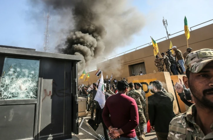 Des membres et partisans du Hachd al-Chaabi, coalition de paramilitaires dominée par des factions pro-Iran, incendient une tourelle devant l'ambassade des Etats-Unis à Bagdad le 31 décembre 2019