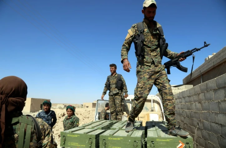 Des Forces démocratiques syriennes (FDS) déchargent des caisses de munitions fournies par la coalition dirigée par les États-Unis, dans un village au nord de Raqa le 7 juin 2017