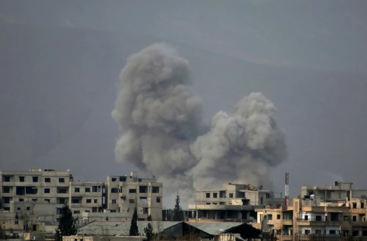 De la fumée s'élève au-dessus de la ville de Misraba, dans la partie rebelle de la Ghouta orientale, après des bombardements du régime, le 10 mars 2018