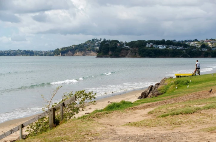 Un homme regarde la mer à Orewa, au nord d'Auckland, le 5 mars 2021