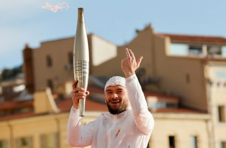 Le rappeur Jul brandissant la flamme sur le Vieux-Port Ă Marseille, le 8 mai 2024