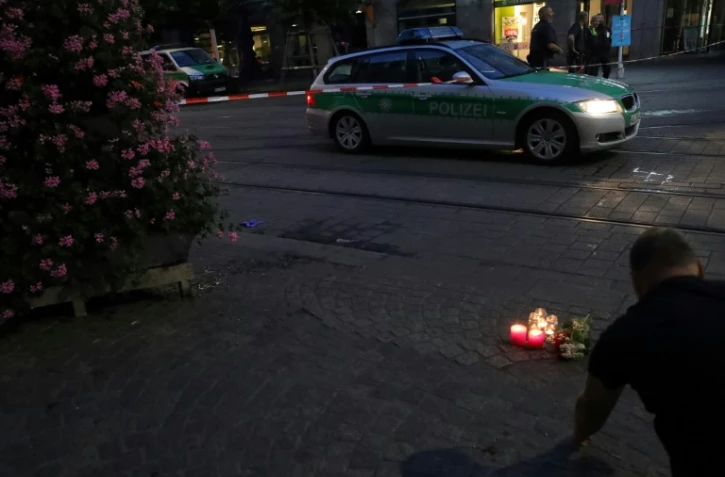 Fleurs et des bougies en hommage aux victimes d'une attaque meurtrière dans le centre-ville de Wuerzburg, dans le sud de l'Allemagne, le 25 juin 2021
