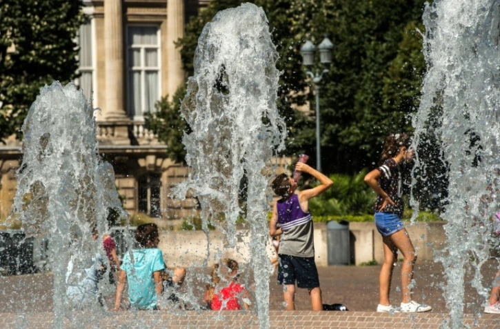 Des personnes se rafraîchissent sous les fontaines, le 24 août 2016 à Lille
